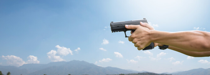 9mm pistol gun holding in hand of gunshooter, soft and selective focus. © Sophon_Nawit