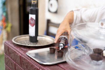  Traditional Portuguese liqueur Ginja in chocolate shots on the street in the medieval fortress of Obidos