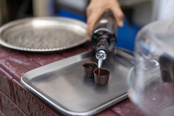 Traditional Portuguese liqueur Ginja in chocolate shots on the street in the medieval fortress of Obidos