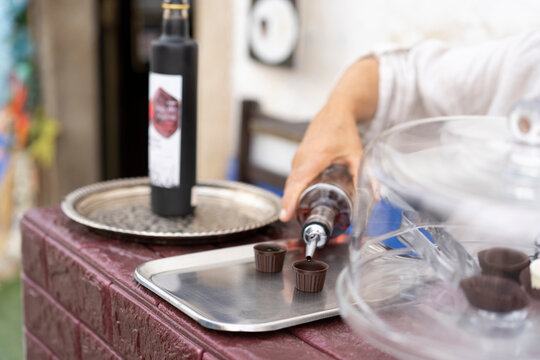  Traditional Portuguese liqueur Ginja in chocolate shots on the street in the medieval fortress of Obidos