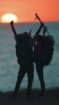 The travelers have fun on the sea shore on sunset background. slow motion