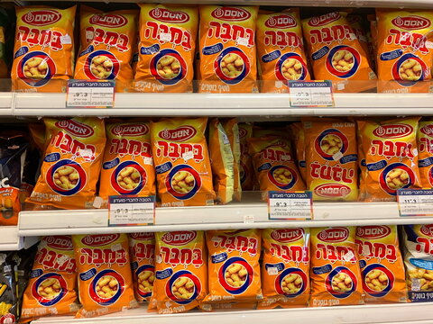  Display with snacks in a store. Translation: Bissli, chips, bamba, cheetos. Israeli snacks in assortment