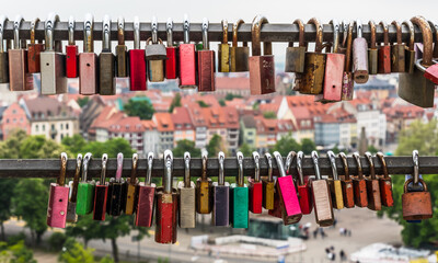 Two poles with love locks, in the background houses of Erfurt, Germany