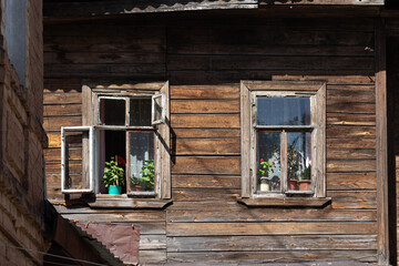 geraniums in pots on the windowsill of a dilapidated residential building, Russia 2023