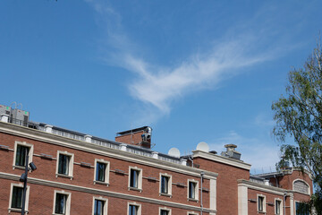 Fototapeta na wymiar a cloud in the form of a flying angel in the blue sky above the building