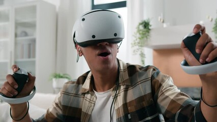 African American man exploring virtual reality experience at home 3d video game wonder amazed excited guy play cyber gaming with controllers VR glasses helmet using joysticks metaverse world say wow