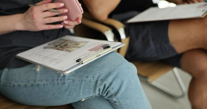 People fill out visa forms for us with passports and dollars in line at embassy. Standard process for gaining access to country and residence permit in America