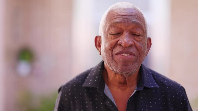 Portrait of a black senior man close-up face looking at camera with neutral expression. African American elderly person in 70s
