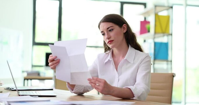 Worried office worker complains about reading bad news in paper letter. Bad news and bank debt