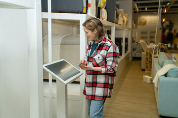 Woman uses the self-service kiosk in the store