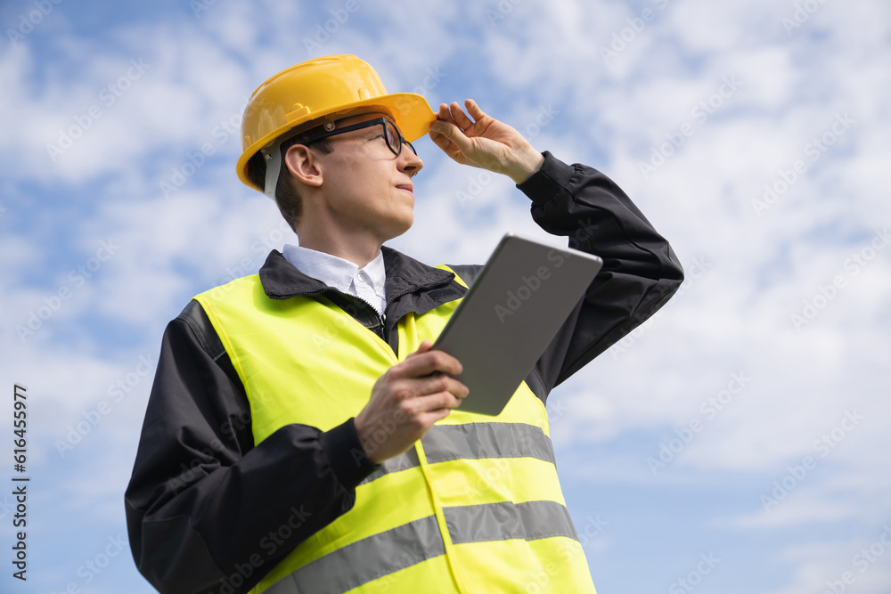 Aufkleber engineer with digital tablet on a background of blue sky.
