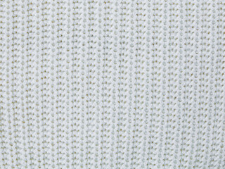 Texture of white woolen fabric, hand-knitted, openwork knitting. Knitted texture of woolen openwork clothes