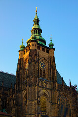Fototapeta na wymiar Tower with golden clock against blue sky. Saint Vitus Cathedral, Wenceslas and Adalbert Cathedral in Hradcany. Famous touristic place and romantic travel destination in Prague, Czech Republic