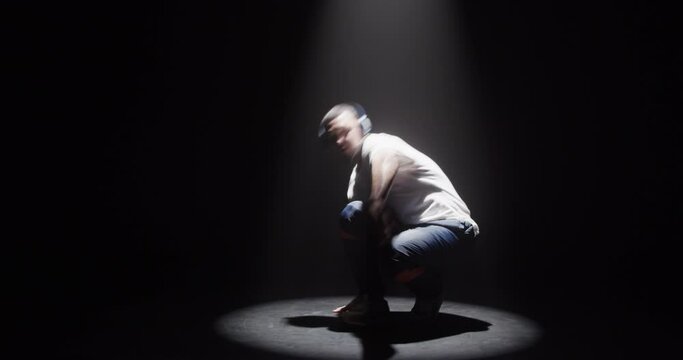 Male dancer in spotlight dancing breakdance