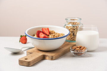 Granola in bowl with strawberries on light background with copy space. Food breakfast background