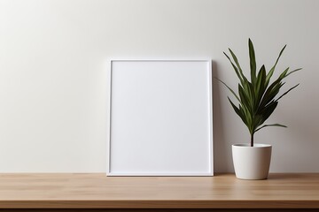 Vertical photo frame mockup in an empty room with a white wall, adorned with plants on a wooden table.
