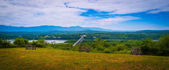 Hudson valley hill, meadow, and river with a view of Rip Van Winkle Bridge in upstate New York