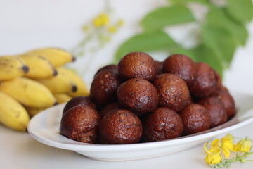 Unniyappam. Delicious sweet rice fritters made with a batter of rice, banana, jaggery, ghee fried coconut pieces, black sesame seeds and flavored with cardamom