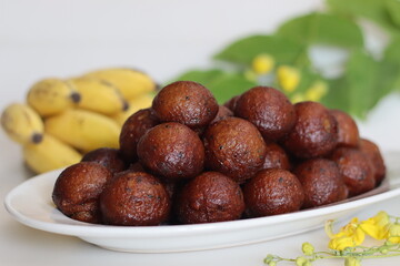 Unniyappam. Delicious sweet rice fritters made with a batter of rice, banana, jaggery, ghee fried coconut pieces, black sesame seeds and flavored with cardamom