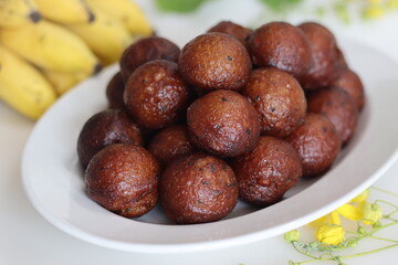 Unniyappam. Delicious sweet rice fritters made with a batter of rice, banana, jaggery, ghee fried coconut pieces, black sesame seeds and flavored with cardamom