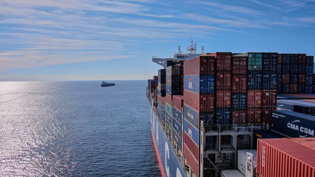 Manzanillo, Colima, Mexico -12.18.2022 -Ultra large container ship approaching to the rocky land, another vessels around. View from aft part port side of the ship.