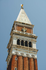 Fototapeta na wymiar Close up look of ancient old tower of church saint mark san marco with impressive details on top 