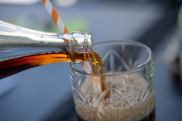 détail d'un versement d'un soda dans un verre avec une paille