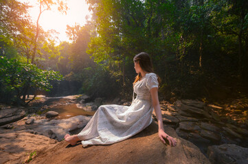 beautiful woman in white dress in deep forest, elf princess fairy tale concept
