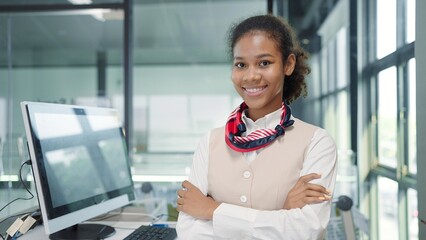 Close up smiling face of young american african women flight attendant on the ground office a service standing with arms crossed looking at camera - Powered by Adobe