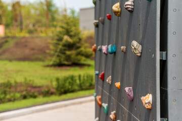 Grey wall with climbing holds in park
