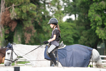 雨の日に乗馬の練習をする少女