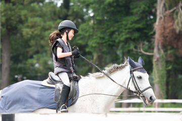 雨の日に乗馬の練習をする少女