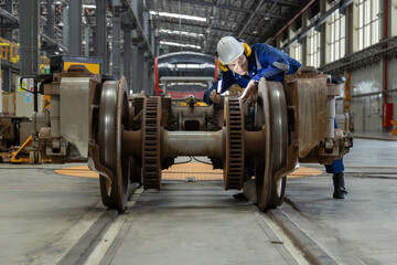 Fototapeta na wymiar Engineer checks spare parts list and maintains mass transit locomotives in Asia