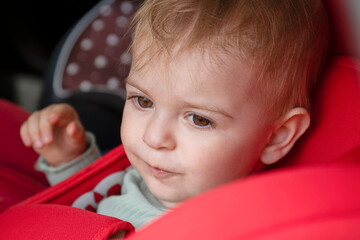 Portrait of  toddler girl sitting in car seat. Child transportation safety