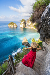 Young woman traveler relaxing and enjoying the beautiful view at diamond beach in Nusa Penida island, Bali