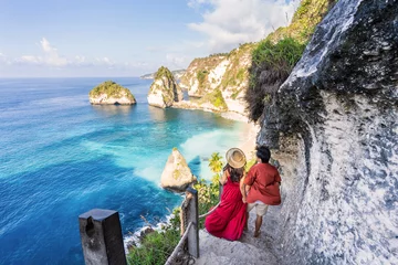 Photo sur Plexiglas Bali Young couple traveler relaxing and enjoying the beautiful view at diamond beach in Nusa Penida island, Bali