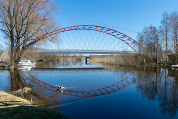 Obraz premium spring landscape with Ema river entering Lake Võrtsjärv in Estonia, bridge over river, reflections in calm river water