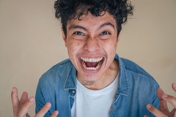 Young curly man wear denim clothes with depression face. The photo is suitable to use for man expression advertising and fashion life style.