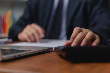 Fototapeta premium Man using calculator working with data analysis and financial planning accounting and bookkeeping tasks. Business marketing investment analysis economy Information growth concept.