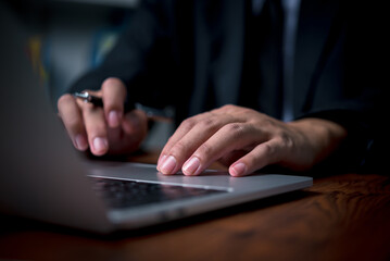 Business man hands working and typing on laptop computer keyboard, searching information, internet social networks, distance job online technology concept.