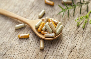 Herbal medicine in capsules from herb leaf on rustic wooden table with copy space for medical background. healthy eating with natural product for good living.