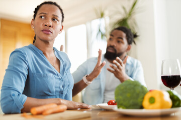 Displeased black couple arguing during lunch at dining table