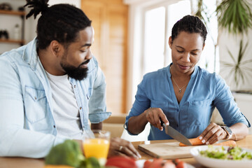 Fototapeta na wymiar Happy black couple preparing healthy meal at home
