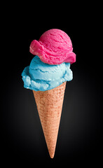 Pink and blue ice cream in a cone on a dark background