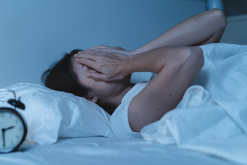 Close-up alarm Young Asian woman have insomnia on the bed
