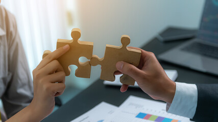 Closeup image of business people connecting couple puzzle wood jigsaw, teamwork, success, goals,...