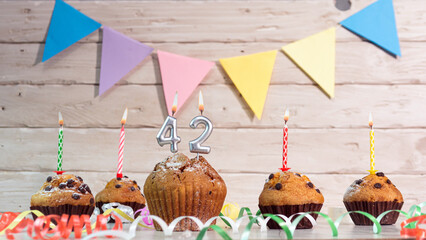 Festive birthday cakes with candles. Birthday background with numbers  42. Anniversary cards on a...