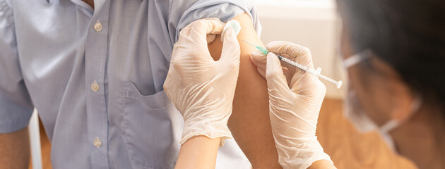 Covid-19,coronavirus, elderly asian adult man getting vaccine from doctor or nurse giving shot to mature patient at clinic. Healthcare, immunization, disease prevention against flu or virus pandemic.