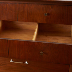 Mid-century modern low dresser. Vintage walnut furniture. Close-up of an open drawer.