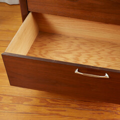 Mid-century modern low dresser. Vintage walnut furniture. Close-up of an open drawer.